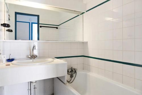 une salle de bain blanche avec un lavabo et une baignoire dans l'établissement Résidence Port Bourgenay - maeva Home - 2 Pièces 5 Personnes Confort MAE-5965, à Talmont-Saint-Hilaire