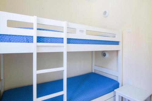 sypialnia z 2 łóżkami piętrowymi i niebieską pościelą w obiekcie Résidence le Hameau des Issambres - maeva Home - Studio 5 Personnes - Sélection MAE-5969 w mieście Les Issambres