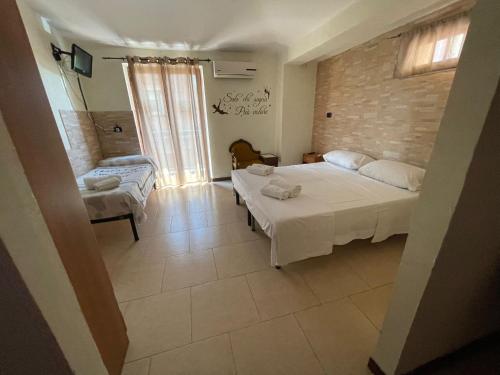 a small room with two beds and a window at La Casa Dei Sogni in Gallico