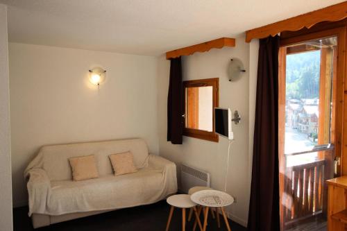 un salon avec un canapé et une fenêtre dans l'établissement Chalets De La Vanoise - LES CHALETS DE LA VANOISE - CV5104 MAE-1674, à Villarodin-Bourget