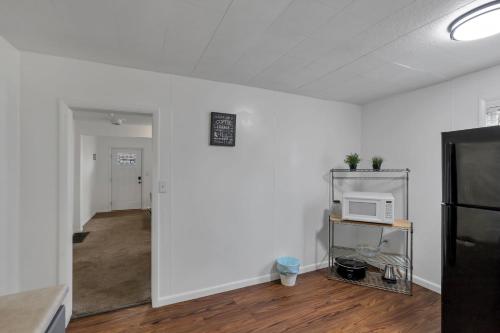 a room with a white wall and a microwave on a shelf at Housepitality - The Southside Ranch in Columbus