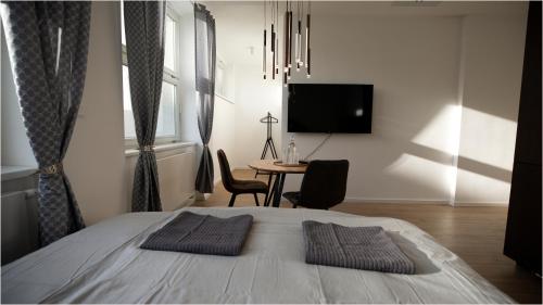 um quarto com uma cama, uma mesa e uma televisão em LUXURY APARTMENT IN CITY CENTRUM by OTA group em Bratislava