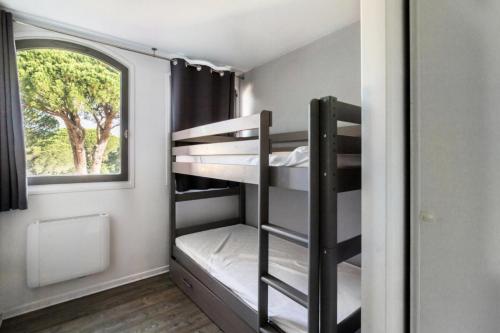een kamer met 2 stapelbedden en een raam bij Résidence Saint-Raphaël Valescure - maeva Home - Appartement 3 pièces 6 pe 80 in Valescure