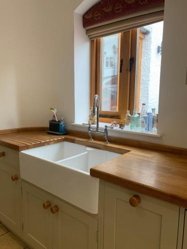 a kitchen with a sink and a window at Stable Cottage in Tettenhall