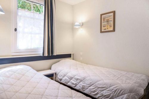 une chambre avec deux lits et une fenêtre dans l'établissement Résidence Port Bourgenay - maeva Home - Appartement 2 pièces 5 personnes - Sélection MAE-8432, à Talmont-Saint-Hilaire