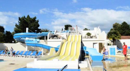 - un toboggan aquatique dans une piscine avec des personnes y séjournant dans l'établissement Mobil-home 4 pers. proche plage - Mobil-home 3 Pièces 4 Personnes MAE-8963, à Saint-Jean-de-Monts