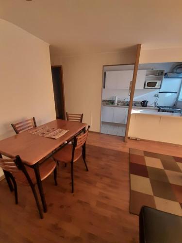 a dining room with a table and chairs and a kitchen at Departamento vallenar in Vallenar