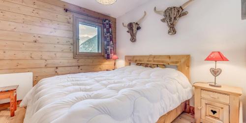 a bedroom with a bed and a window withanimal heads on the wall at Résidence Les Alpages - 3 Pièces pour 6 Personnes 854 in Champagny-en-Vanoise