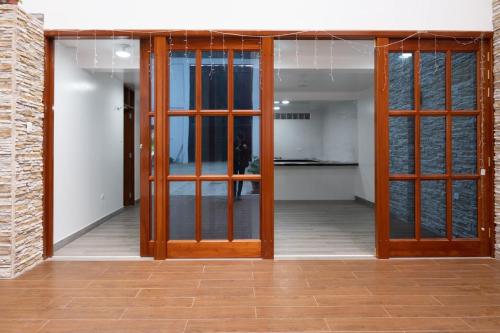 an open hallway with wooden doors and a brick wall at Estancia Entre Las Nubes in Chachapoyas