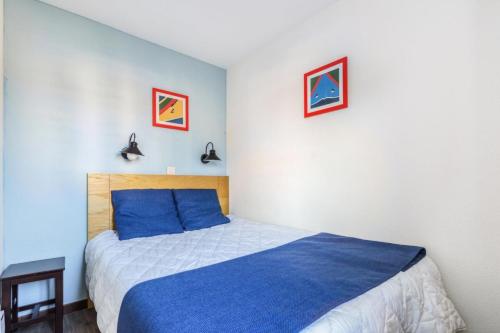 une chambre avec un lit et deux tableaux au mur dans l'établissement Résidence Port du Crouesty - maeva Home - Appartement 2 pièces 5 Personnes - Confort MAE-9736, à Arzon