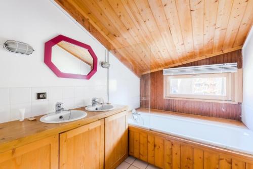 uma casa de banho com 2 lavatórios e um tecto de madeira em Chalet Arketa 14 pers. au pied des pistes - Maeva Particuliers - 8 Pièces 14 Personnes Prestige 139510 em Avoriaz