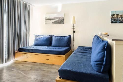 Cette petite chambre comprend un lit bleu et une fenêtre. dans l'établissement Résidence Port du Crouesty - maeva Home - Appartement 2 pièces 5 personnes - Confort - Vue mer MAE-0450, à Arzon