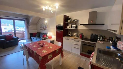 Il comprend une cuisine et un salon avec une table. dans l'établissement Résidence Loup Argente - Superbe duplex très lumineux, face aux pistes MAE-3944, à Montgenèvre