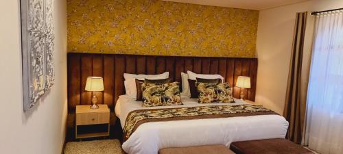 a bedroom with a large bed with a wooden headboard at Hotel Boutique Guatika in Tibasosa