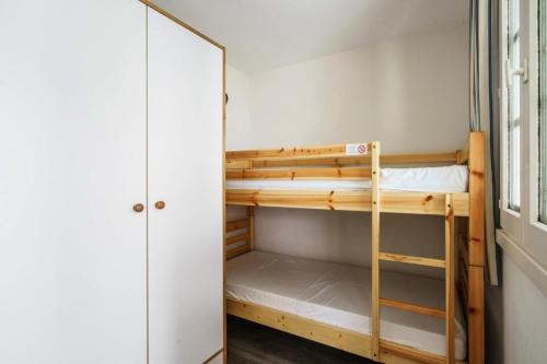 Cette chambre comprend des lits superposés et un miroir. dans l'établissement Résidence Port du Crouesty - maeva Home - Studio 5 personnes - Confort MAE-0594, à Arzon