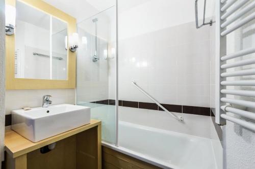 une salle de bain avec un lavabo blanc et une douche dans l'établissement Résidence Port du Crouesty - maeva Home - Studio 5 personnes - Confort MAE-0594, à Arzon