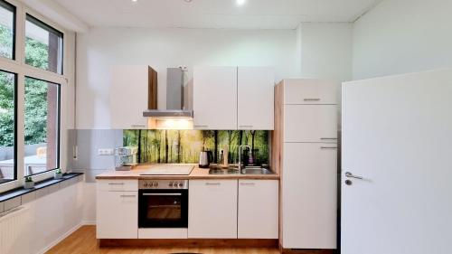 uma cozinha com armários brancos e um frigorífico em 135m²-Apartment I max. 8 Gäste I Zentral I Küche I Balkon I Parken I WLAN em Lünen