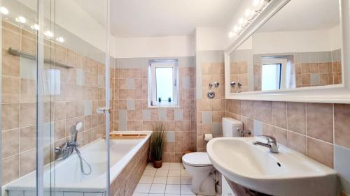 een badkamer met een wastafel, een bad en een toilet bij 135m²-Apartment I max. 8 Gäste I Zentral I Küche I Balkon I Parken I WLAN in Lünen