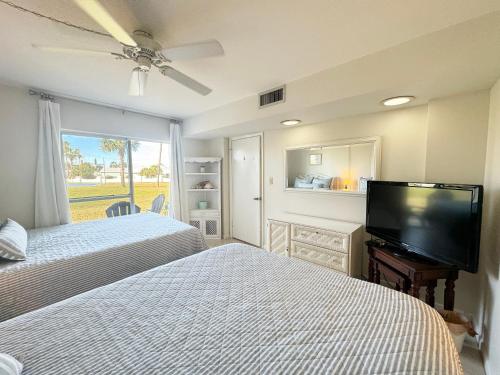 1 dormitorio con 2 camas y TV de pantalla plana en 511 El Matador, en Fort Walton Beach