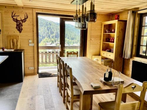 une salle à manger avec une grande table et des chaises en bois dans l'établissement Résidence Chez Simone - Chalet Simone avec vue sur un village typique du Val d'Arly MAE-6374, à Flumet