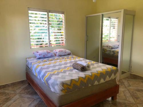 1 dormitorio con 1 cama grande y espejo en Típica casa dominicana a 12 minutos de la playa, en Las Galeras