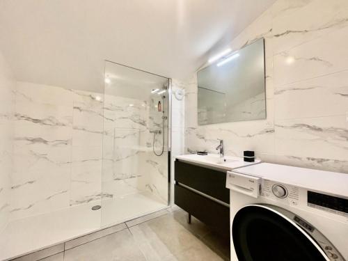 a white bathroom with a shower and a washing machine at Résidence Res Cristal - 3 Pièces pour 4 Personnes 384 in Notre-Dame-de-Bellecombe