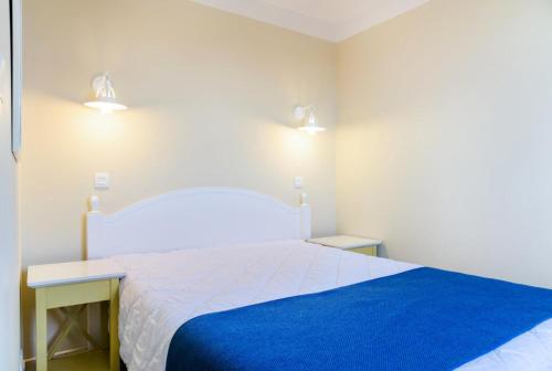- une chambre dotée d'un grand lit blanc avec des draps bleus dans l'établissement Résidence Port Bourgenay - maeva Home - 2 Pièces 5 Personnes Sélection MAE-2813, à Talmont-Saint-Hilaire