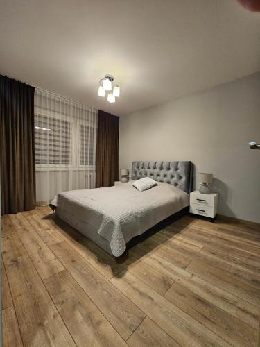 1 dormitorio con 1 cama y suelo de madera en Pleasant stay 1-bedroom apartment, en Šiauliai