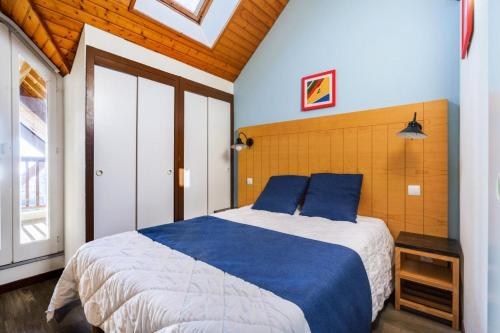 une chambre avec un grand lit avec des oreillers bleus dans l'établissement Résidence Port du Crouesty - maeva Home - 2 Pièces 7 Personnes - Confort MAE-2873, à Arzon