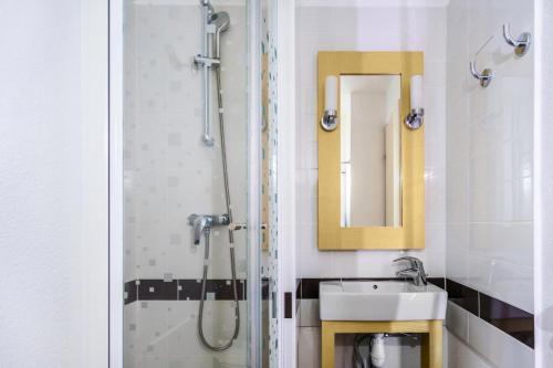 une salle de bain avec un lavabo et une douche avec un miroir dans l'établissement Résidence Port du Crouesty - maeva Home - 2 Pièces 7 Personnes - Confort MAE-2873, à Arzon