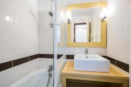 une salle de bain avec un lavabo, une baignoire et un miroir dans l'établissement Résidence Port du Crouesty - maeva Home - Appartement 2 pièces 5 personnes - Confort MAE-2909, à Arzon