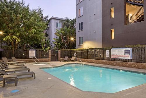 a swimming pool with lounge chairs next to a building at Playa Vista Bedroom Retreat! in Glendale