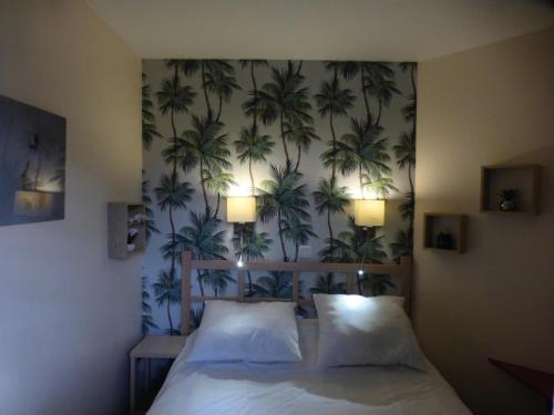 - une chambre avec un lit et un mur orné de palmiers dans l'établissement Résidence le Village de Cap Esterel - maeva Home - Appartement 2 Pièces 4 Personnes - Sélection MAE-3461, à Saint-Raphaël