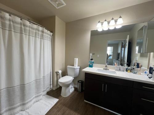 a bathroom with a toilet and a sink and a mirror at Playa Vista Bedroom Retreat! in Glendale
