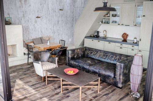 ein Wohnzimmer mit einem Ledersofa und einem Tisch in der Unterkunft Award-winning cottage on lake Thun- New in Thun