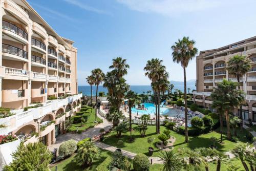 une vue aérienne d'un complexe avec piscine et palmiers dans l'établissement Résidence Cannes Verrerie - maeva Home - 2 Pièces 5 Personnes Confort MAE-3572, à Cannes