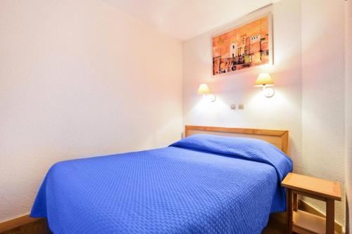 - une chambre avec un lit bleu dans l'établissement Résidence Cannes Verrerie - maeva Home - 2 Pièces 5 Personnes Confort MAE-3572, à Cannes