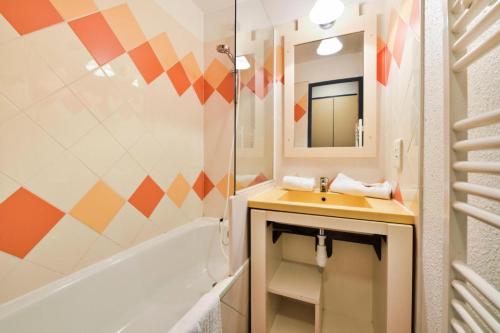 une salle de bain avec un lavabo, une baignoire et un miroir dans l'établissement Résidence Cannes Verrerie - maeva Home - 2 Pièces 5 Personnes Confort MAE-3572, à Cannes