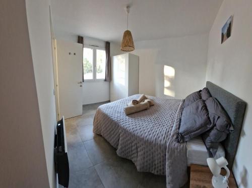 une chambre avec un lit avec un animal en peluche dessus dans l'établissement Appartement proche de Saint Cyprien, à Lecci