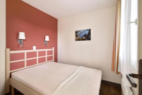 une petite chambre avec un lit blanc et une fenêtre dans l'établissement Résidence le Village de Cap Esterel - maeva Home - Appartement 2 Pièces 5 Personnes - Sélection MAE-3729, à Saint-Raphaël