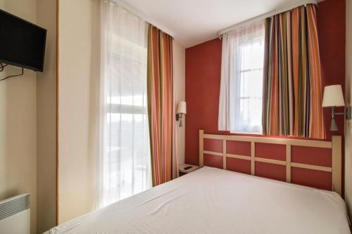 une chambre avec un lit blanc et une fenêtre dans l'établissement Résidence le Village de Cap Esterel - maeva Home - Appartement 2 Pièces 5 Personnes - Prestige MAE-3815, à Saint-Raphaël