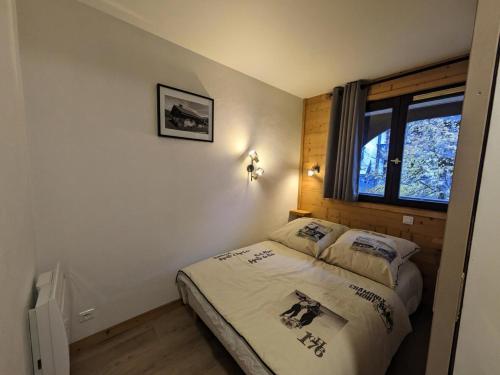 een kleine slaapkamer met een bed en een raam bij Résidence Jonquille - 2 Pièces pour 4 Personnes 974 in Chamonix-Mont-Blanc