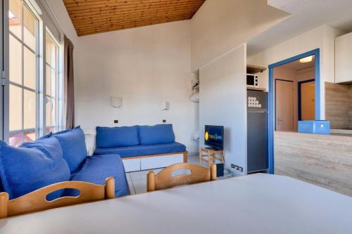 un salon avec un canapé bleu et une table dans l'établissement Résidence Port Bourgenay - maeva Home - 2 Pièces 7 Personnes - Sélection MAE-4662, à Talmont-Saint-Hilaire