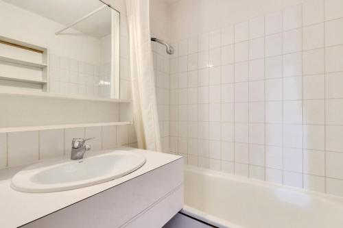 La salle de bains blanche est pourvue d'un lavabo et d'une baignoire. dans l'établissement Résidence Port Bourgenay - maeva Home - 2 Pièces 7 Personnes - Sélection MAE-4662, à Talmont-Saint-Hilaire