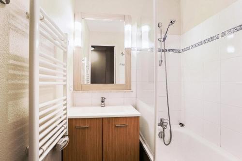 La salle de bains blanche est pourvue d'un lavabo et d'une douche. dans l'établissement Les maisons de Port Guillaume - maeva Home - Maison 3 Pièces 6 Personnes - C 07, à Dives-sur-Mer