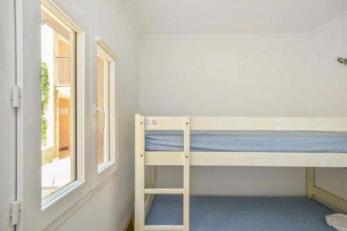 Cette petite chambre comprend des lits superposés et une fenêtre. dans l'établissement Village Pont Royal en Provence - maeva Home - Studio 5 Personnes Selection MAE-4892, à Mallemort