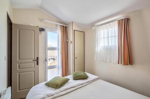 une chambre avec un lit avec deux oreillers dessus dans l'établissement Résidence le Village de Cap Esterel - maeva Home - Appartement 2 pièces 6 personnes - Sélection MAE-4826, à Saint-Raphaël