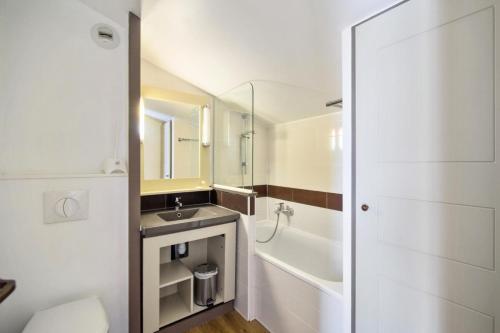 une salle de bain avec un lavabo, une baignoire et des toilettes dans l'établissement Résidence le Village de Cap Esterel - maeva Home - Appartement 2 pièces 6 personnes - Sélection MAE-4826, à Saint-Raphaël