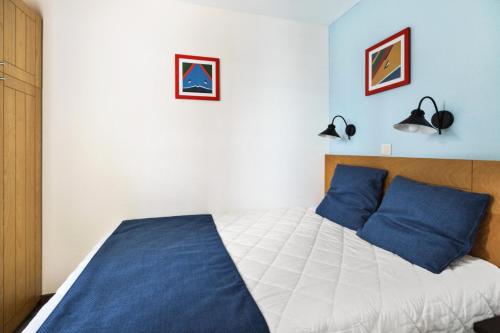 une chambre avec un grand lit avec des oreillers bleus dans l'établissement Résidence Port du Crouesty - maeva Home - 2 pièces 5 personnes - Confort - vue mer MAE-4830, à Arzon