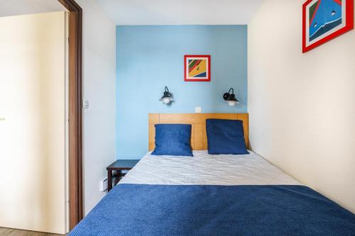 une chambre avec un lit avec des draps bleus et blancs dans l'établissement Résidence Port du Crouesty - maeva Home - Appartement 2 pièces 5 personnes - Confort - Vue sur le lac du Miramar MAE-5295, à Arzon